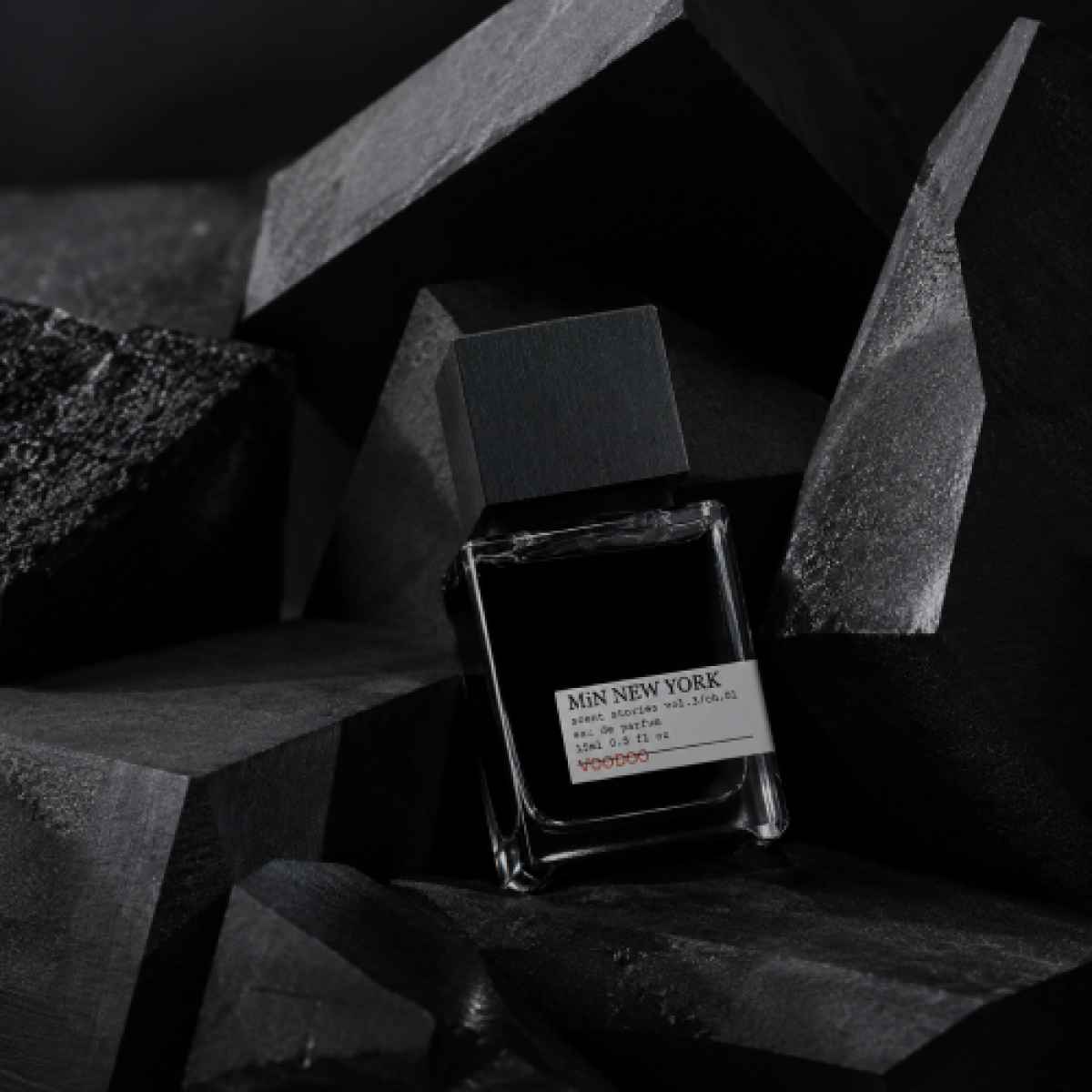 Minimalist MiN NEW YORK perfume bottle displayed among black geometric shapes, used in the niche fragrance influencer campaign case study on Russia-Promo.