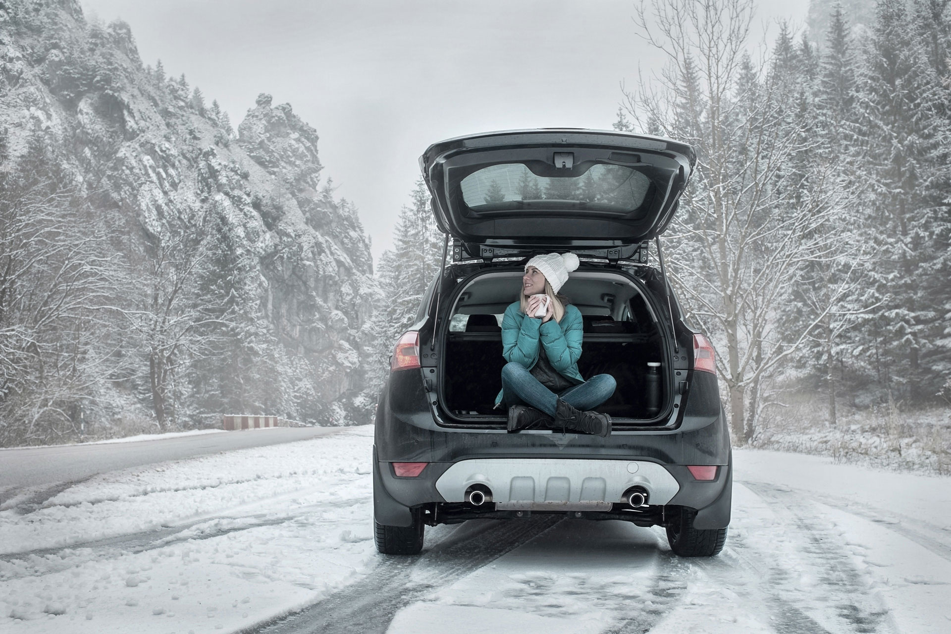 Varta brand image with a woman enjoying a drink in a winter car setting.