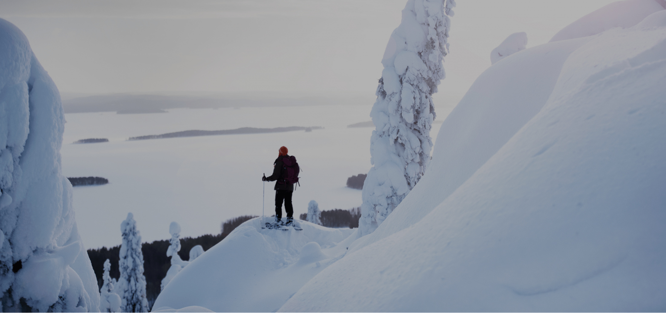 A person hiking in a snow-covered landscape with a backpack in North Karelia, Finland, featured in the Visit Karelia platform case study on Russia-Promo.