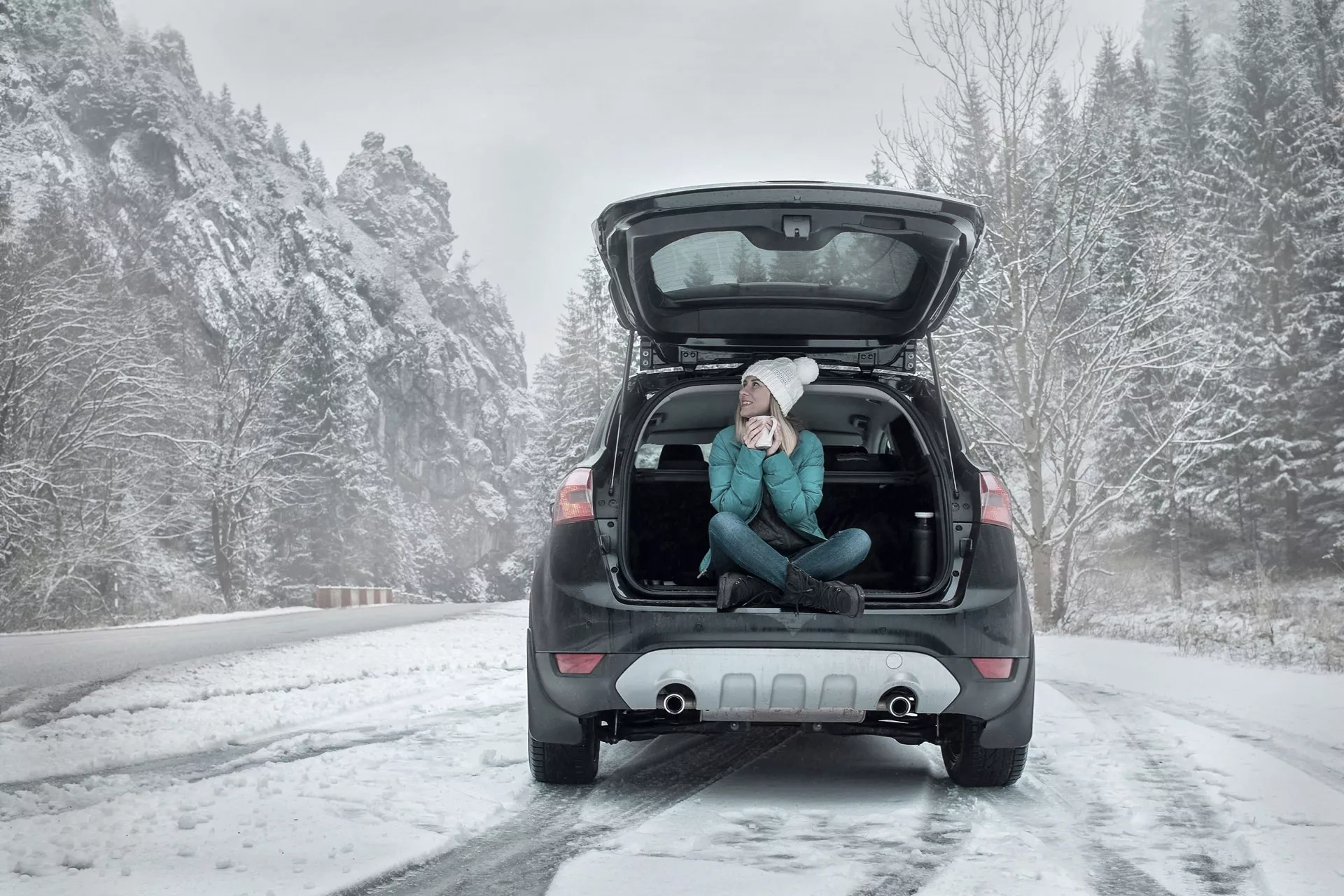 Varta brand image with a woman enjoying a drink in a winter car setting.