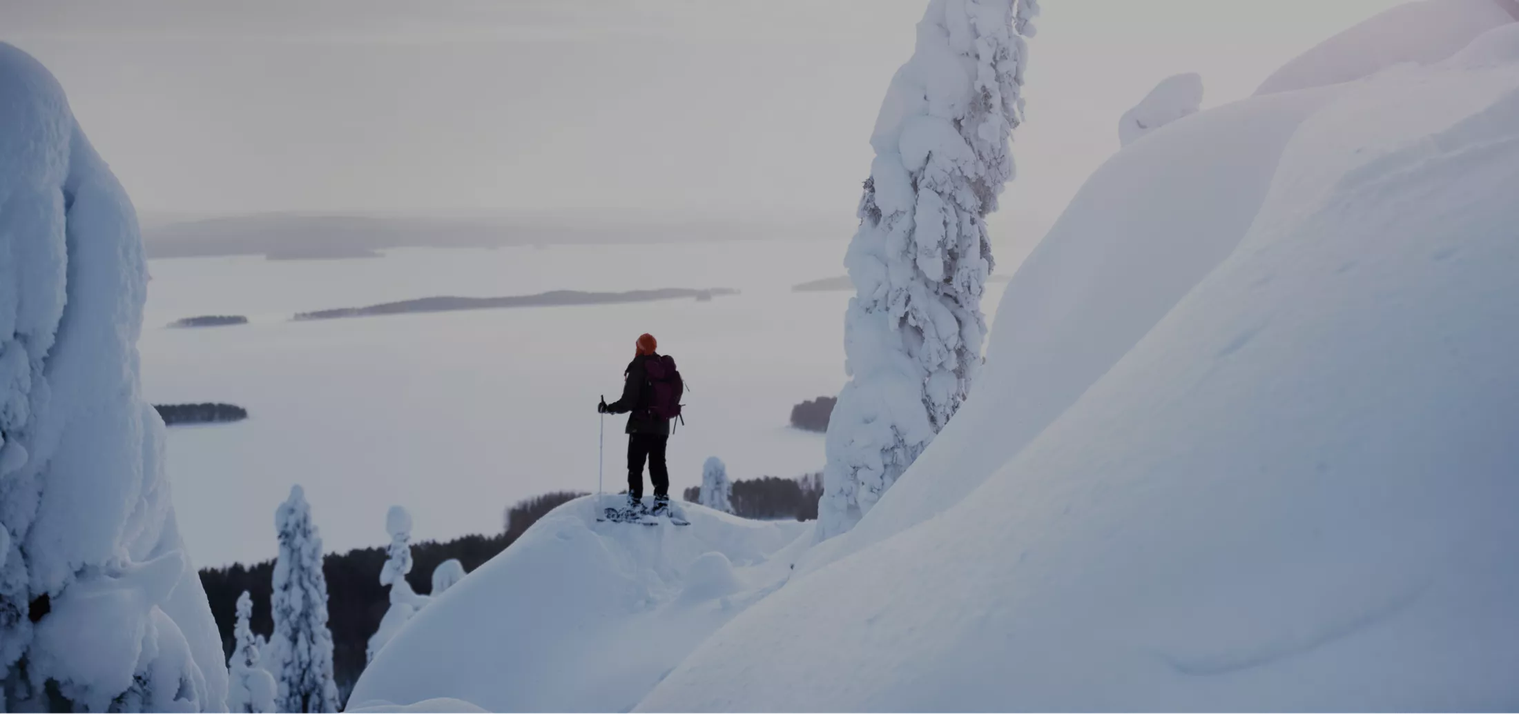 A person hiking in a snow-covered landscape with a backpack in North Karelia, Finland, featured in the Visit Karelia platform case study on Russia-Promo.