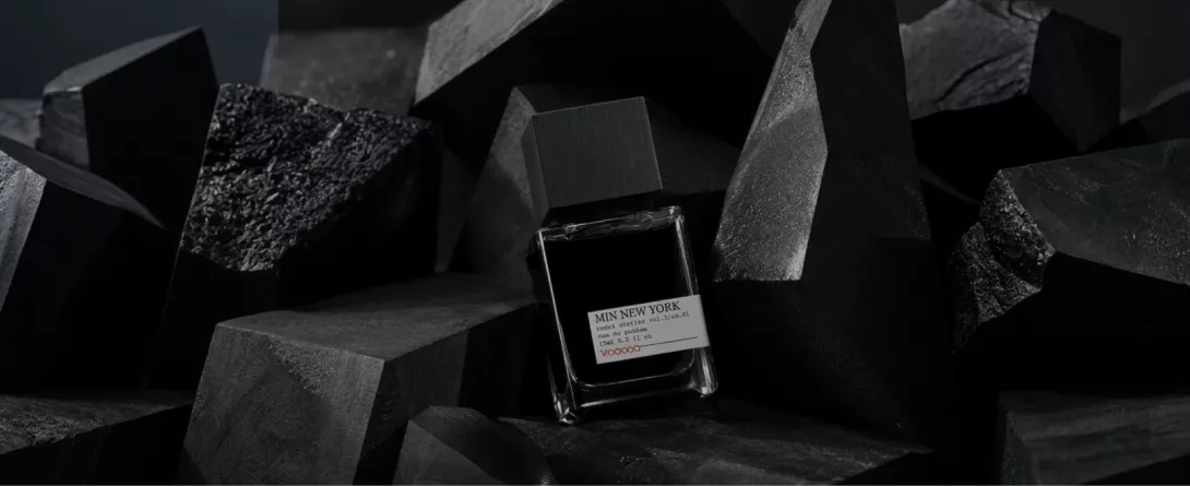 Minimalist MiN NEW YORK perfume bottle displayed among black geometric shapes, used in the niche fragrance influencer campaign case study on Russia-Promo.